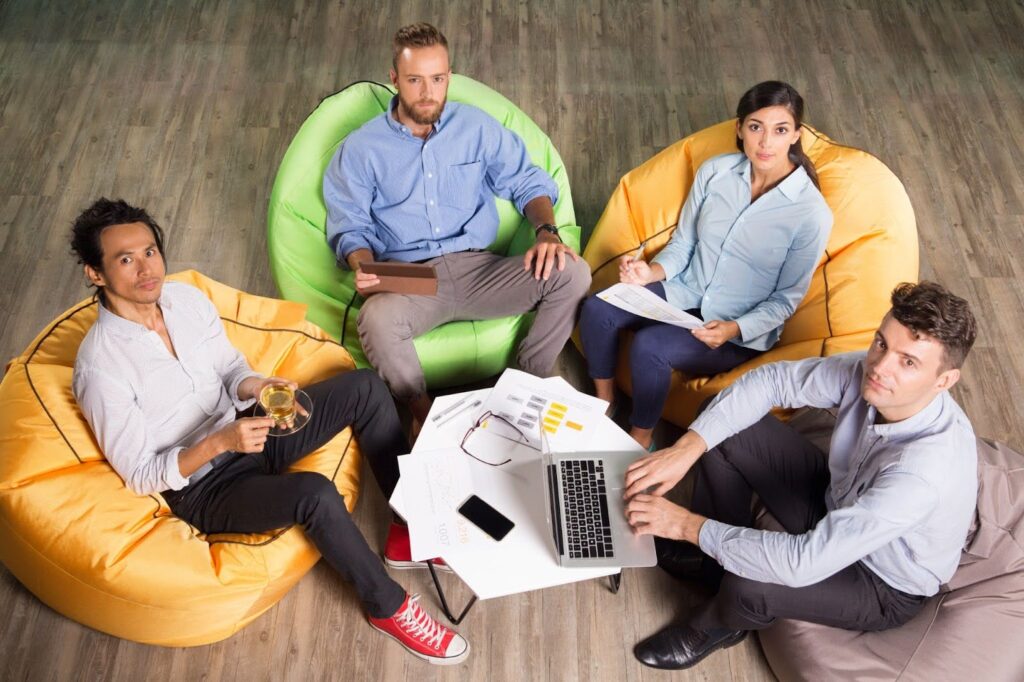 Startup team brainstorming in a relaxed setting, reflecting project management best practices with the help of top PM tools for small teams and efficient task planning apps.