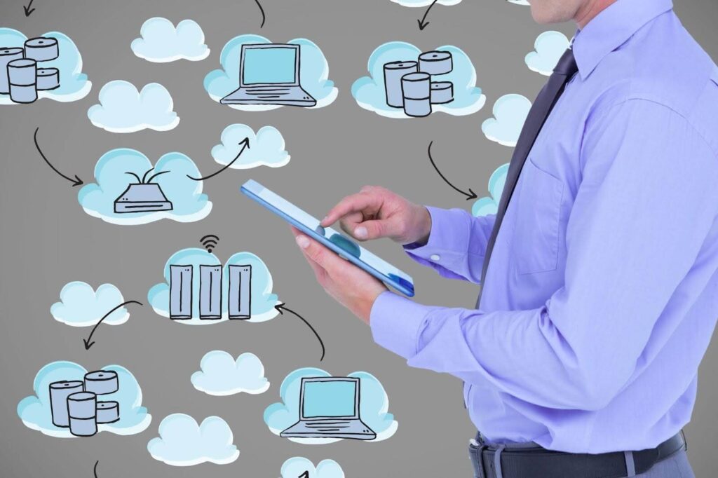 Businessman using a digital tablet in front of hand-drawn cloud computing icons, symbolizing interconnected services and the productivity benefits of cloud-based suites.